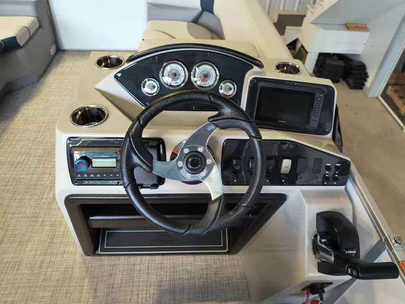 Slide: The Image of 2025 SunCatcher Select 18C boat dashboard with steering wheel, gauges, and controls. - 16