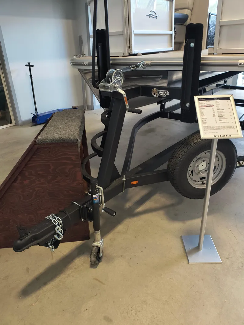 Slide: The Image of 2025 SunCatcher Select 18C boat trailer with hitch and information stand. - 17