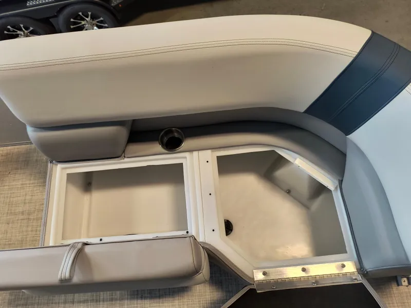 Slide: The Image of 2025 SunCatcher Select 18C boat interior with open storage compartments and cup holder. - 4