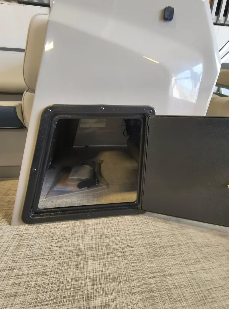Slide: The Image of Open storage compartment in 2025 SunCatcher Select 18C boat interior. - 7