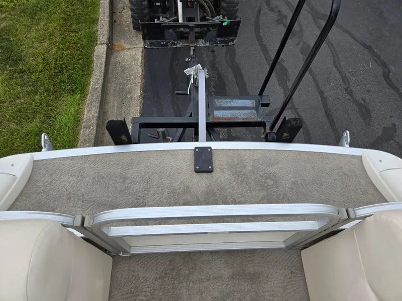 Slide: The Image of 2007 Bennington 2075GL boat interior with trailer hitch, parked on pavement. - 23