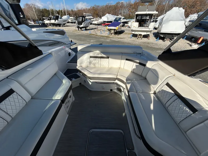 Slide: The Image of 2018 Sea Ray SLX 280 boat interior with white seating and outdoor marina view. - 5