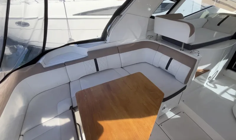Slide: The Image of 2018 Sea Ray Sundancer 350 interior with white seating and wooden table. - 20