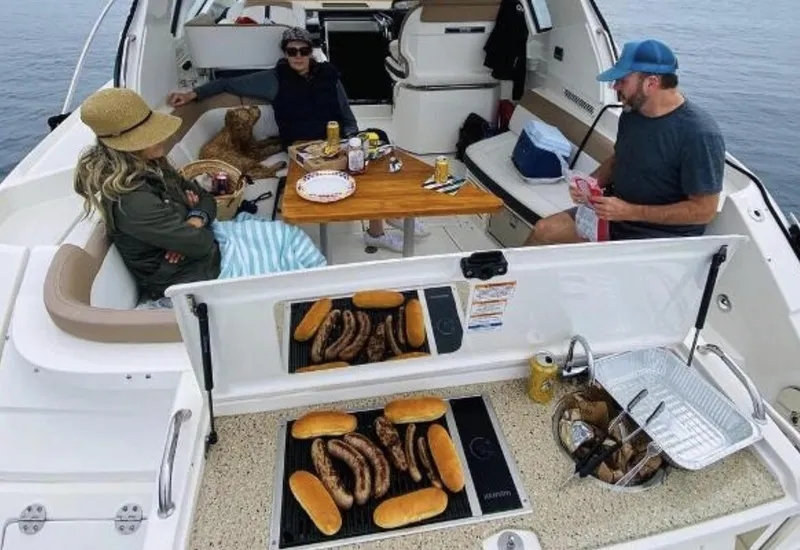 Slide: The Image of People enjoying a meal on a 2018 Sea Ray Sundancer 350 boat. - 32