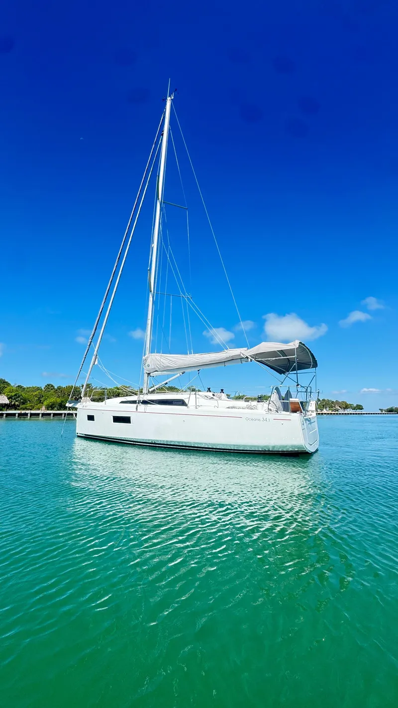 The Image of 2023 Beneteau Oceanis 34.1 sailboat on clear blue water under a bright sky. - 0