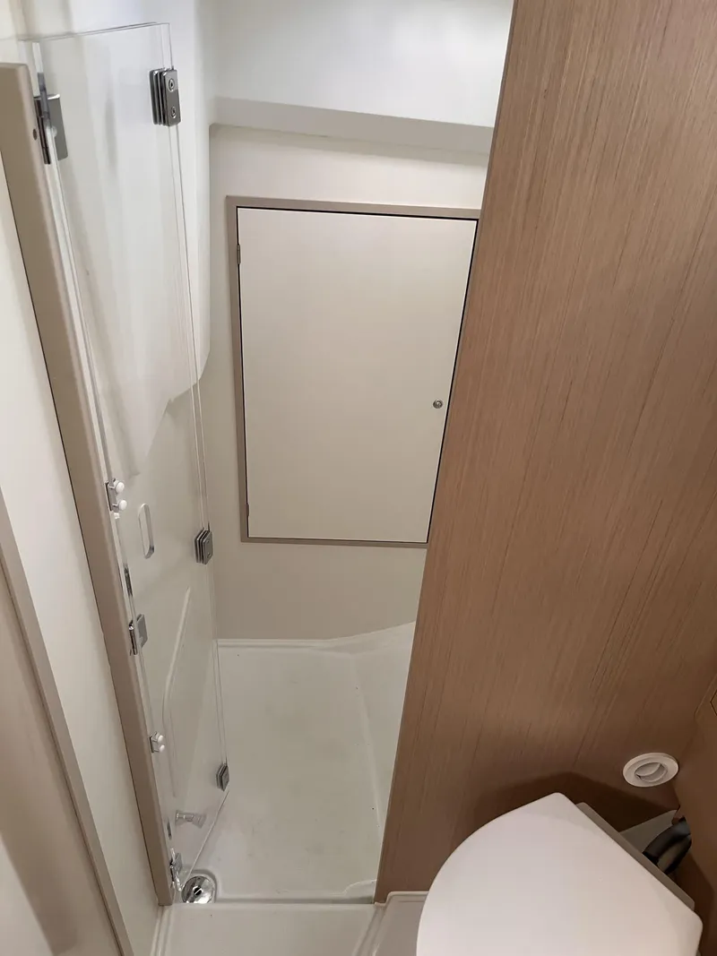 Slide: The Image of 2023 Beneteau Oceanis 34.1 bathroom with shower and wooden paneling. - 11