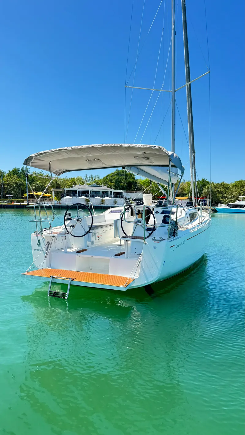 Slide: The Image of 2023 Beneteau Oceanis 34.1 sailboat docked in clear turquoise water. - 3