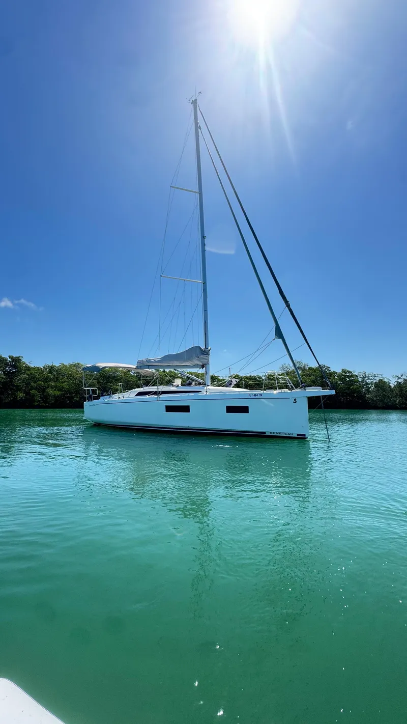 Slide: The Image of 2023 Beneteau Oceanis 34.1 sailboat on calm turquoise water under clear blue sky. - 6
