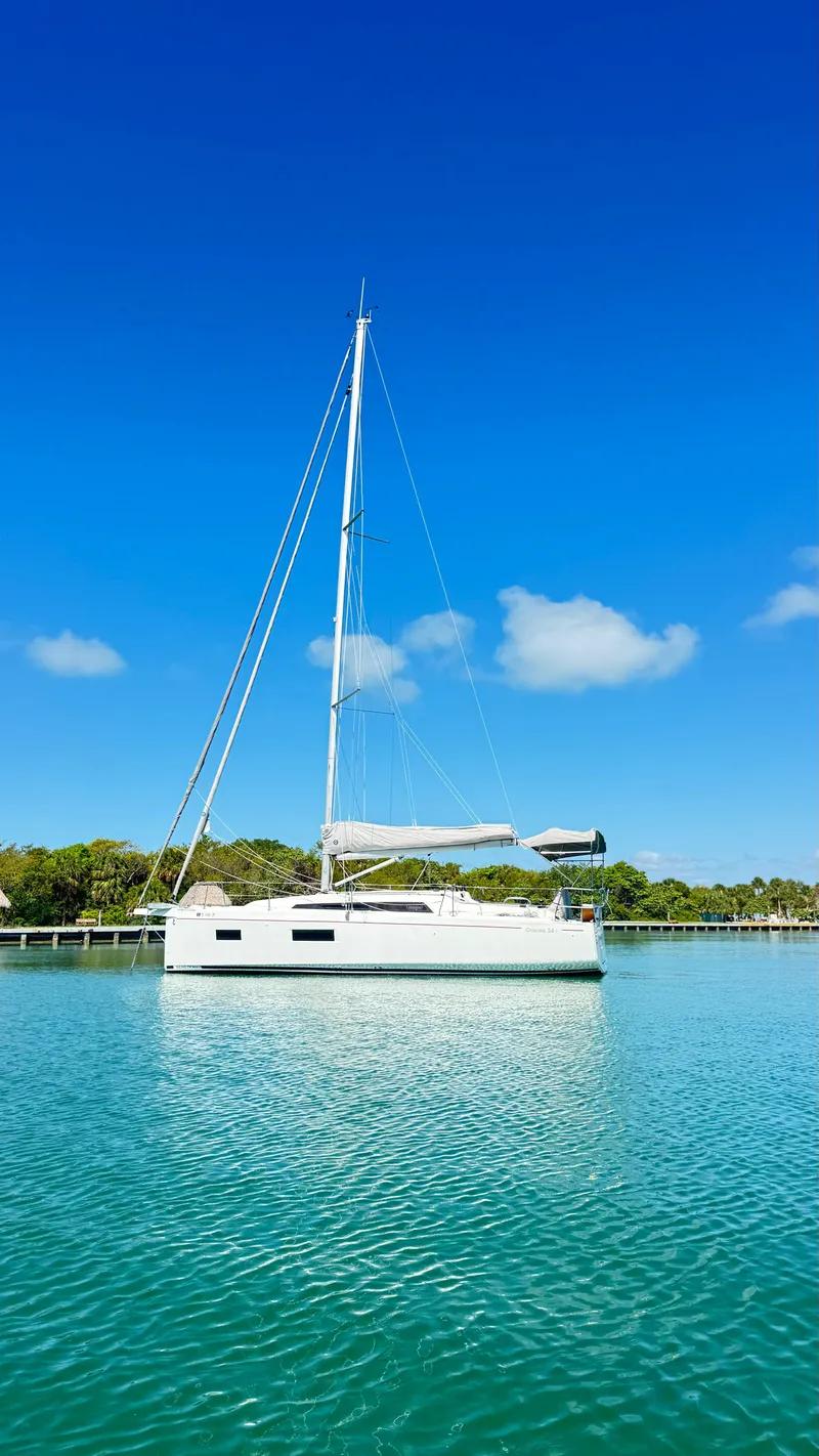 Slide: The Image of 2023 Beneteau Oceanis 34.1 sailboat on calm water under clear blue sky. - 7