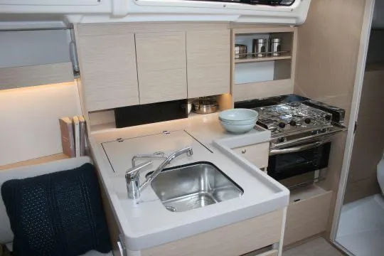 Slide: The Image of 2023 Beneteau Oceanis 34.1 yacht kitchen with modern sink, stove, and storage. - 8