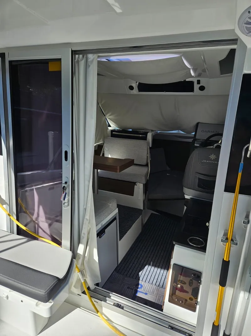 Slide: The Image of Interior view of 2023 Jeanneau NC795 S2 boat, featuring seating and helm area. - 11
