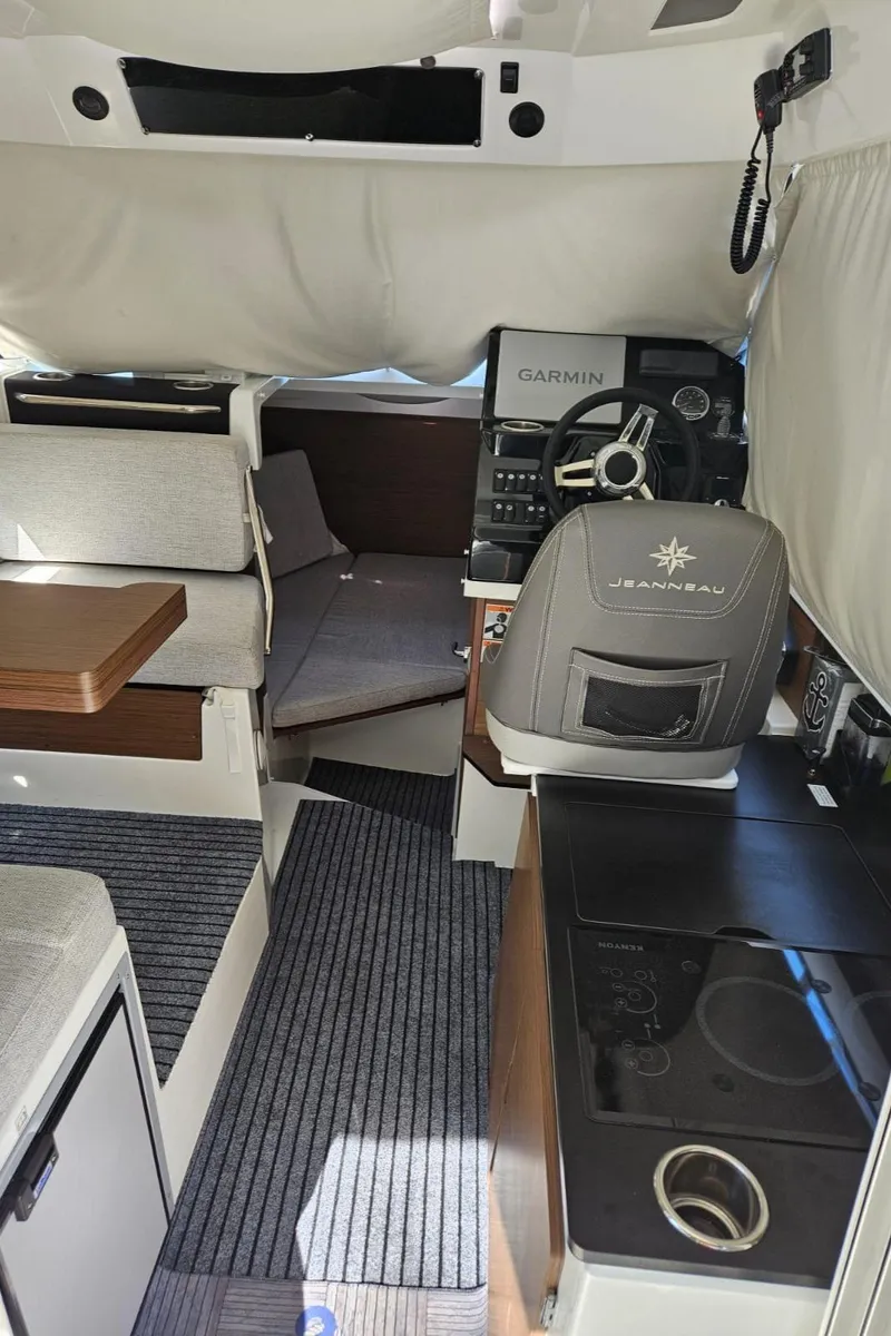 Slide: The Image of Interior of 2023 Jeanneau NC795 S2 boat with helm, seating, and navigation equipment. - 12