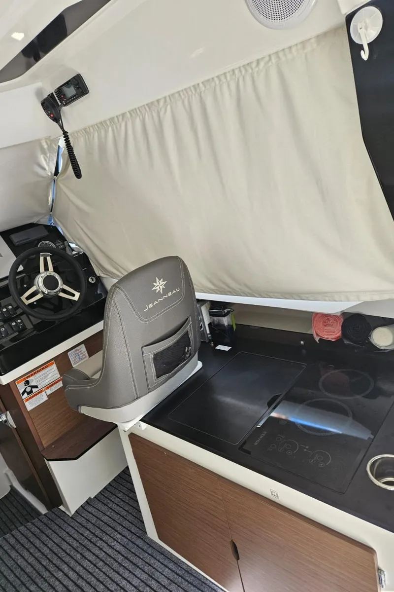 Slide: The Image of Interior of 2023 Jeanneau NC795 S2 boat with steering wheel and kitchenette. - 13