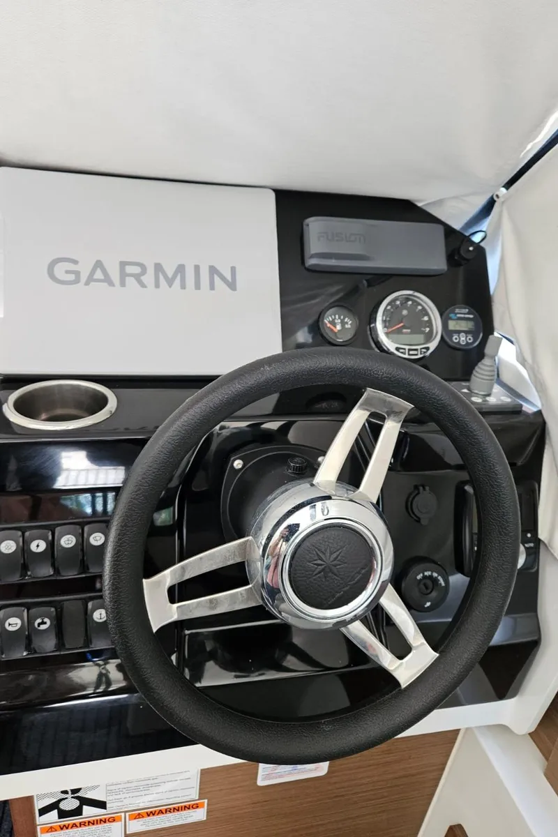 Slide: The Image of Steering wheel and dashboard of 2023 Jeanneau NC795 S2 with Garmin navigation system. - 15