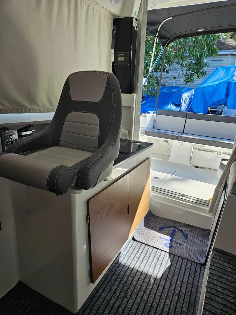 Slide: The Image of 2023 Jeanneau NC795 S2 boat interior with helm seat and cabin view. - 16
