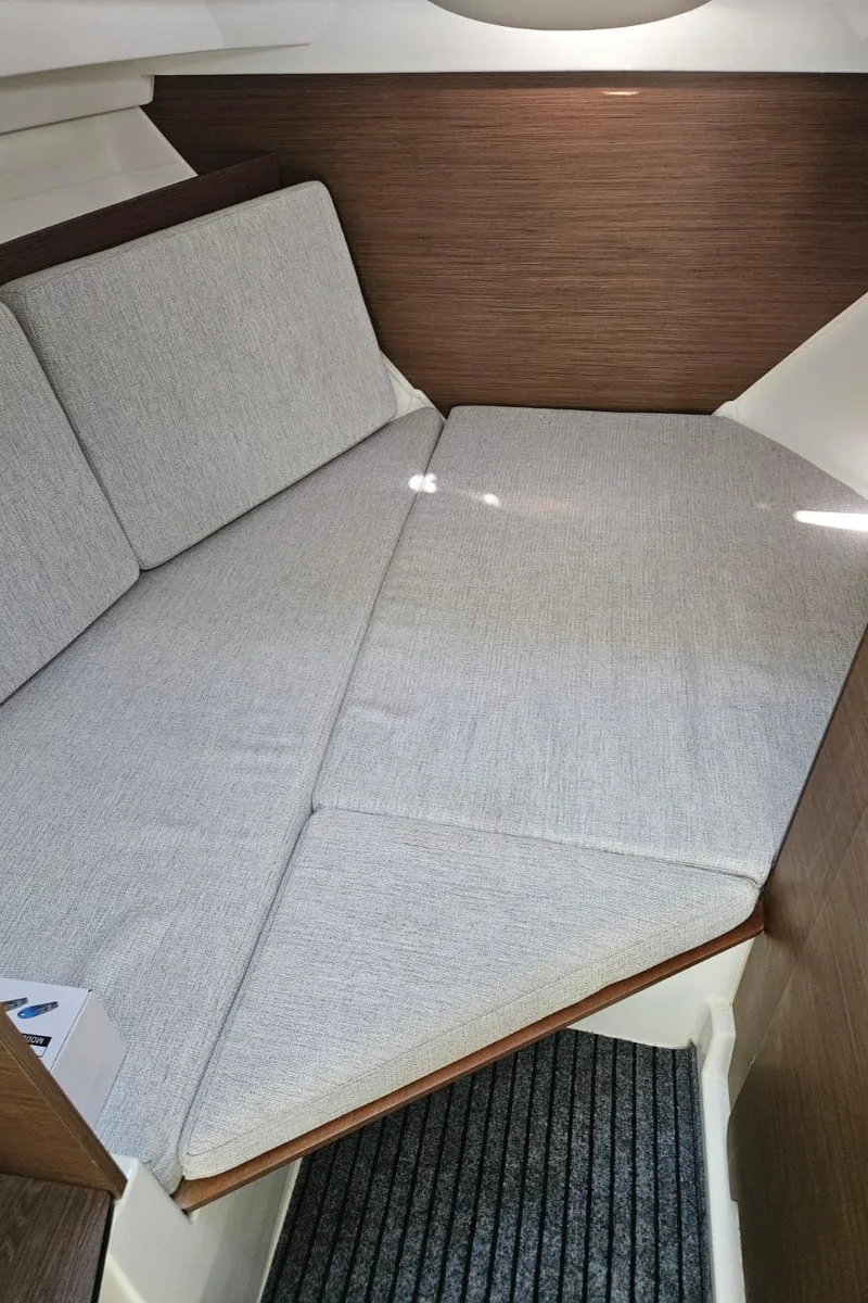 Slide: The Image of 2023 Jeanneau NC795 S2 cabin interior with cushioned seating and wooden accents. - 22