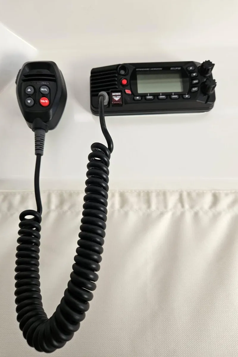 Slide: The Image of VHF radio system on 2023 Jeanneau NC795 S2 boat, featuring a coiled microphone. - 23