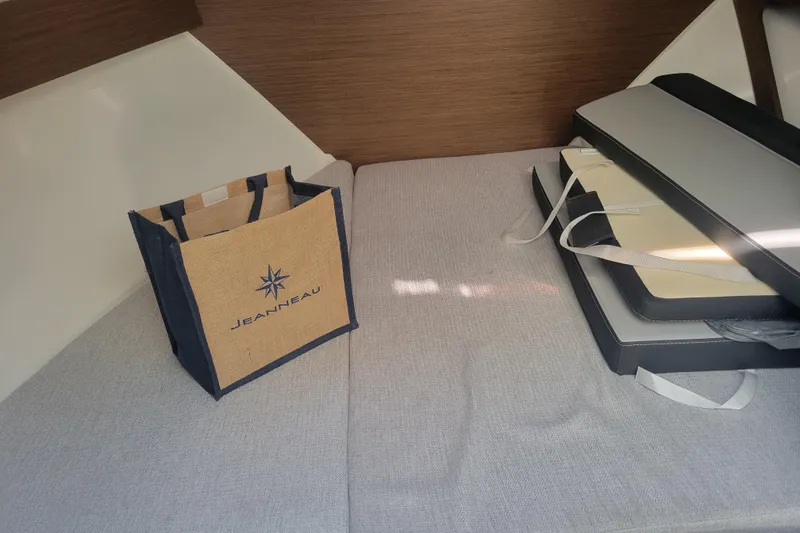 Slide: The Image of 2023 Jeanneau NC795 S2 cabin interior with a branded bag and cushions. - 25