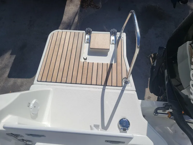 Slide: The Image of 2023 Jeanneau NC795 S2 boat deck with wooden finish and metal railing. - 6