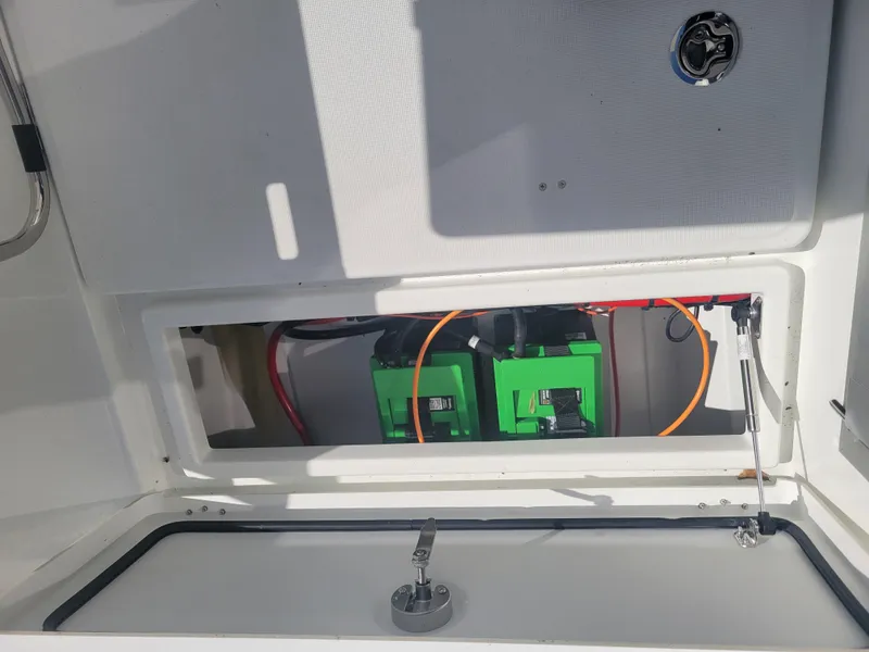 Slide: The Image of 2023 Jeanneau NC795 S2 boat battery compartment with green batteries and wiring. - 7