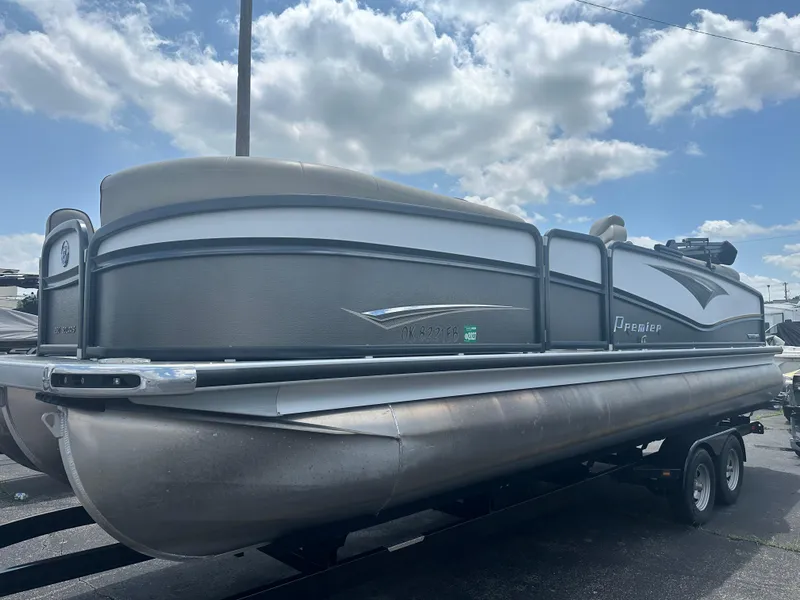 Slide: The Image of 2023 Premier 250 Solaris pontoon boat on trailer under a partly cloudy sky. - 3
