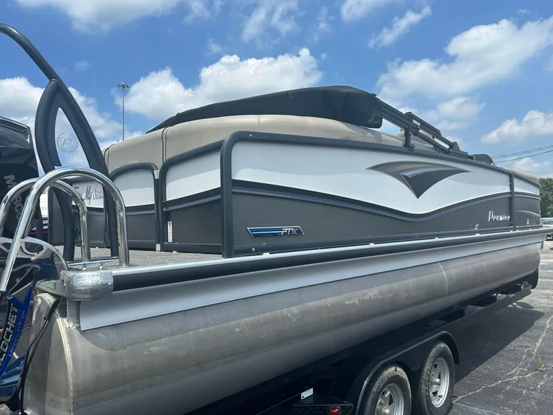 Slide: The Image of 2023 Premier 250 Solaris pontoon boat on trailer under a blue sky. - 5