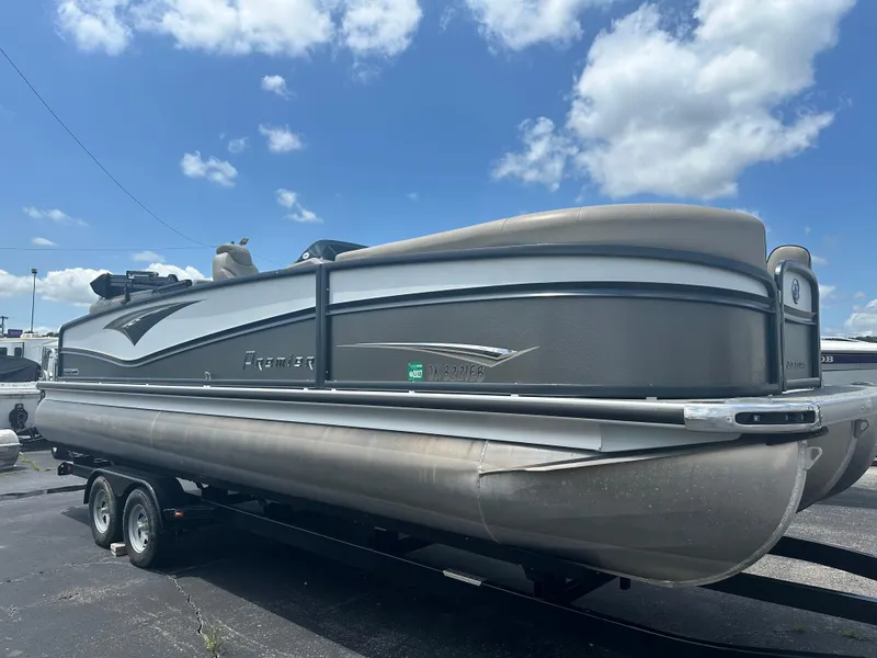 Slide: The Image of 2023 Premier 250 Solaris pontoon boat on trailer under blue sky. - 6