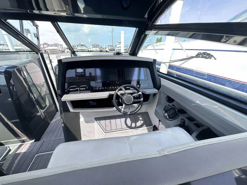 Slide: The Image of Interior of a 2019 Cobalt A36 boat, featuring a modern helm and steering wheel. - 19