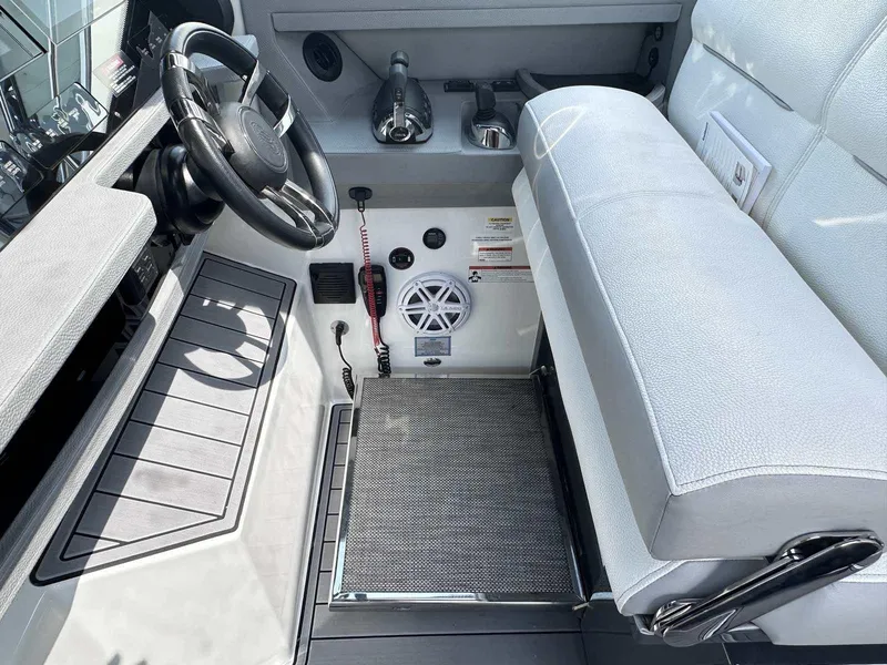 Slide: The Image of 2019 Cobalt A36 boat cockpit with steering wheel, controls, and cushioned seating. - 23