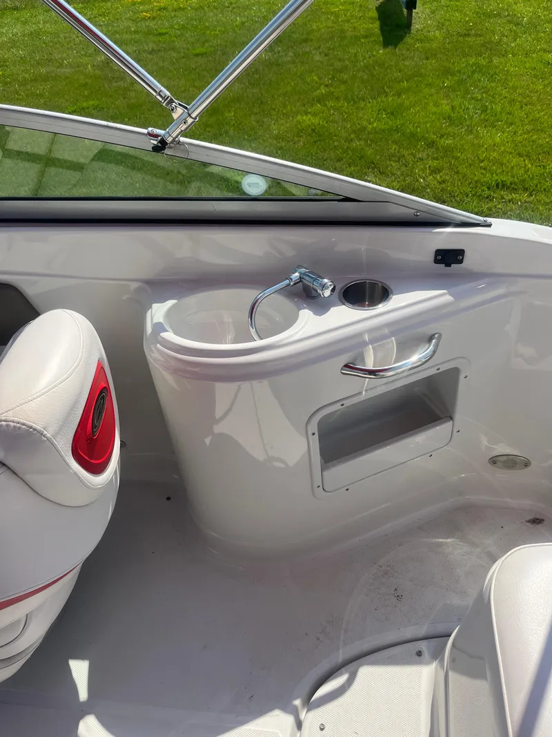 Slide: The Image of 2007 Crownline 220 EX boat interior with sink and seating, featuring white and red accents. - 9
