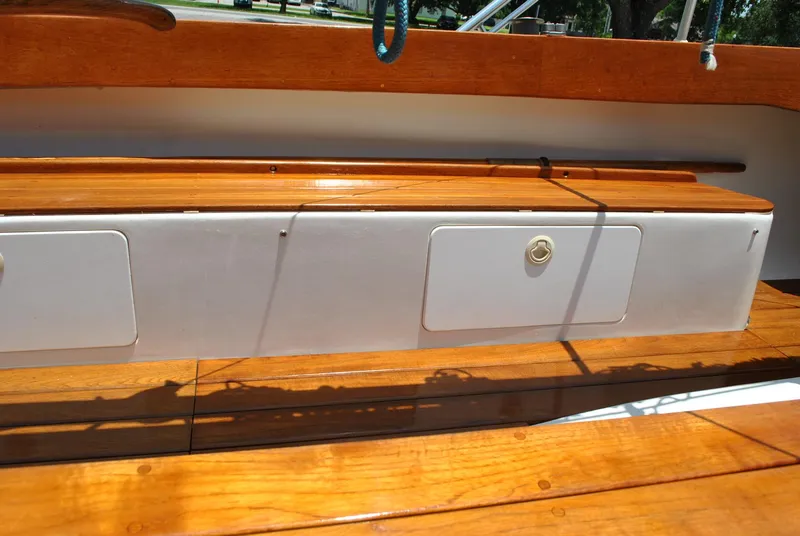 Slide: The Image of 2006 Edey & Duff Sakonnet 23 boat interior with polished wooden seating and storage compartments. - 27