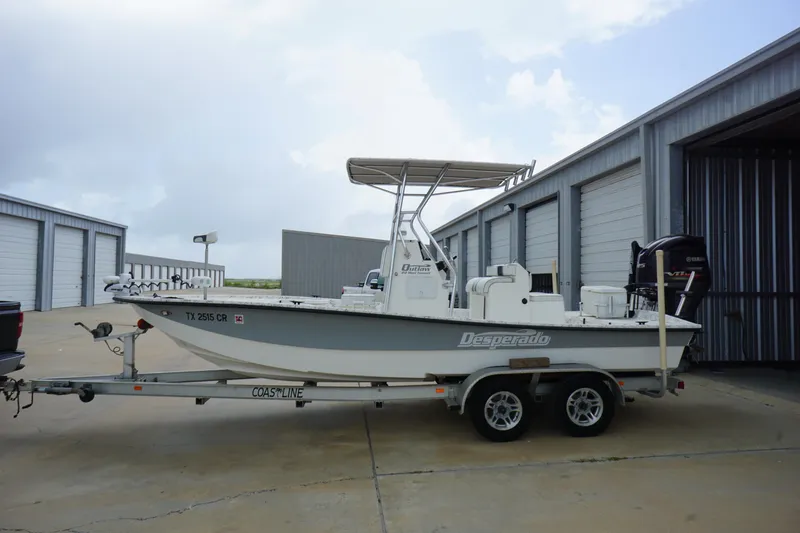 Slide: The Image of 2015 Desperado 22 Outlaw boat on trailer near storage units. - 1