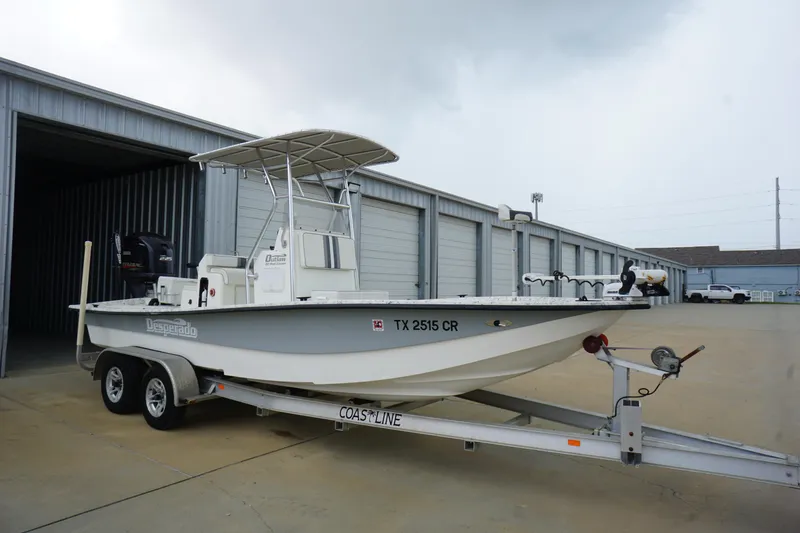 Slide: The Image of 2015 Desperado 22 Outlaw boat on trailer near storage units. - 3