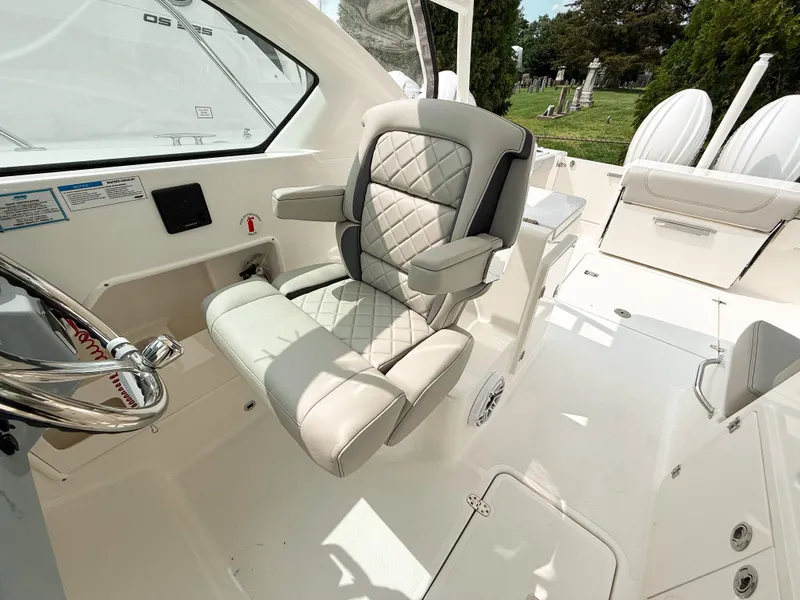 Slide: The Image of 2025 Pursuit DC 266 Dual Console boat interior with luxurious seating and steering wheel. - 14