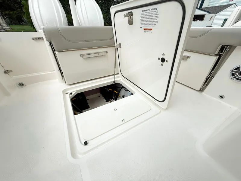 Slide: The Image of 2025 Pursuit DC 266 Dual Console boat with open storage compartment. - 22