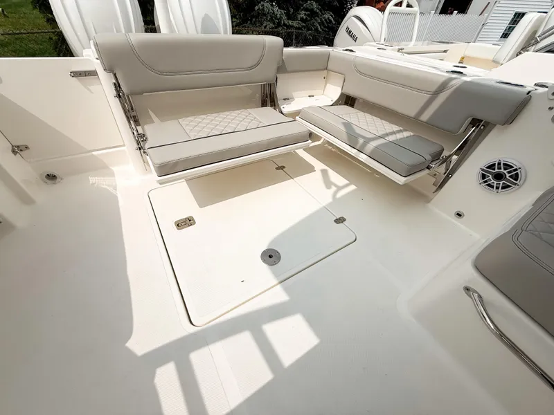 Slide: The Image of 2025 Pursuit DC 266 Dual Console boat interior with foldable seating and storage compartment. - 7