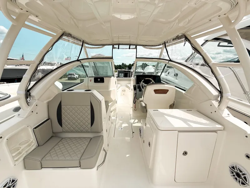 Slide: The Image of 2025 Pursuit DC 266 Dual Console boat interior with seating and helm, showcasing luxury design. - 9