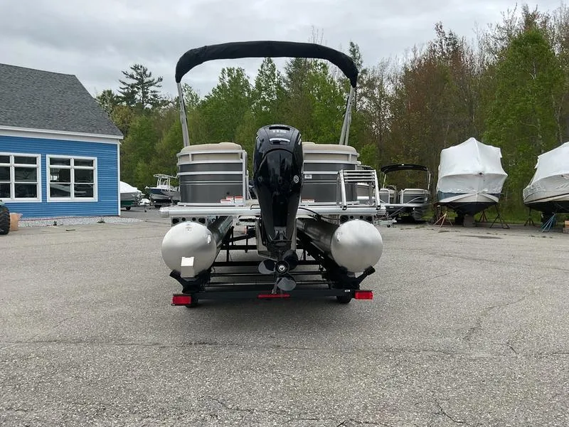 Slide: The Image of 2025 Sun Tracker PARTY BARGE® 22 DLX pontoon boat parked outdoors. - 7