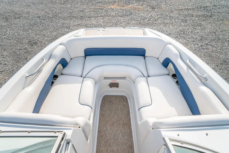 Slide: The Image of 2012 Crownline Eclipse E2 boat interior with white and blue seating, gravel background. - 19