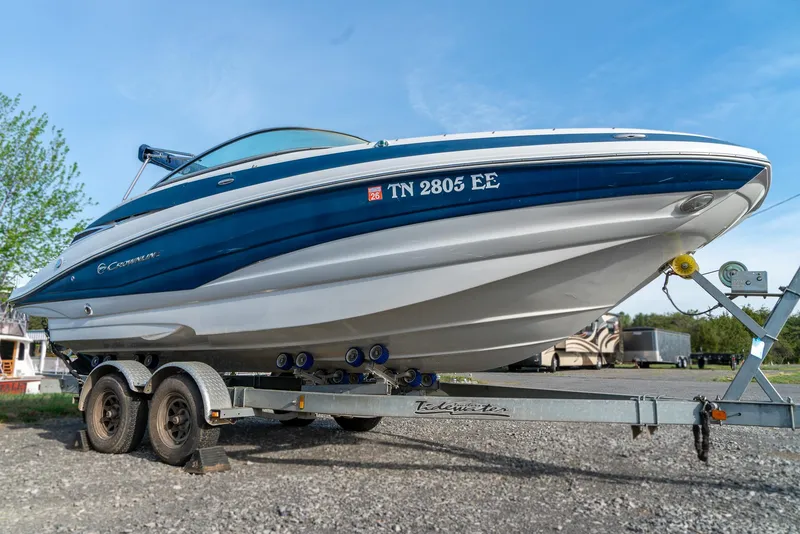 Slide: The Image of 2012 Crownline Eclipse E2 boat on trailer, blue and white, parked outdoors. - 5