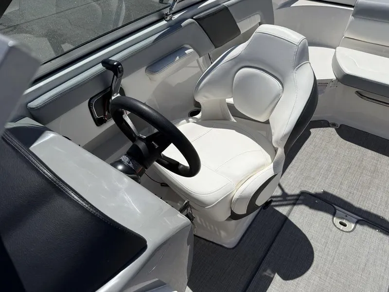 Slide: The Image of 2022 Chaparral 23 SSi boat cockpit with white captain's chair and steering wheel. - 17
