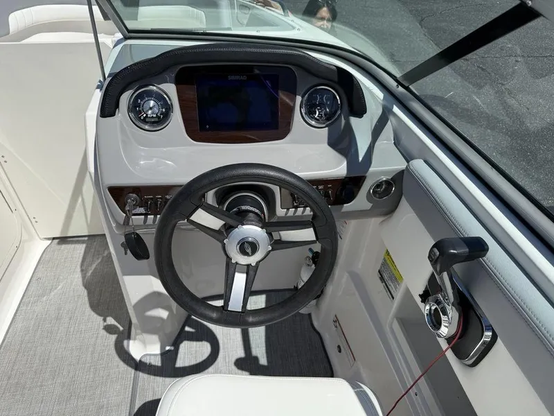 Slide: The Image of 2022 Chaparral 23 SSi boat dashboard with steering wheel and controls. - 18