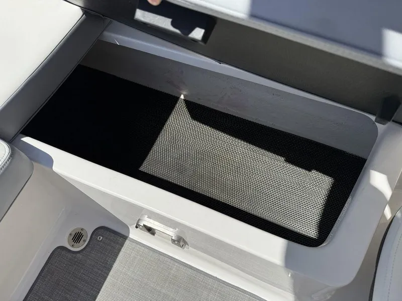 Slide: The Image of 2022 Chaparral 23 SSi boat storage compartment with open lid, showcasing interior space. - 22