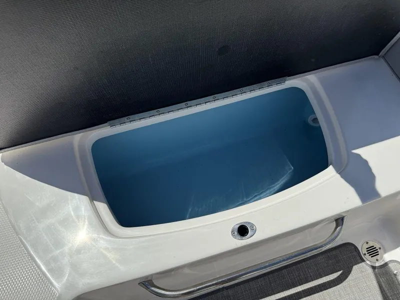 Slide: The Image of 2022 Chaparral 23 SSi boat storage compartment, open and empty, with a blue interior. - 23