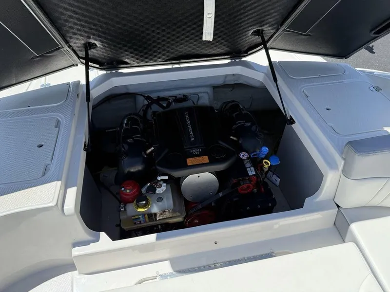 Slide: The Image of 2022 Chaparral 23 SSi boat engine compartment with open hatch, showcasing engine components. - 27