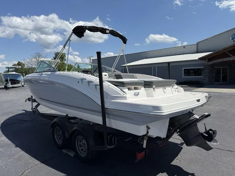 Slide: The Image of 2022 Chaparral 23 SSi boat on trailer, parked outdoors under a clear sky. - 9