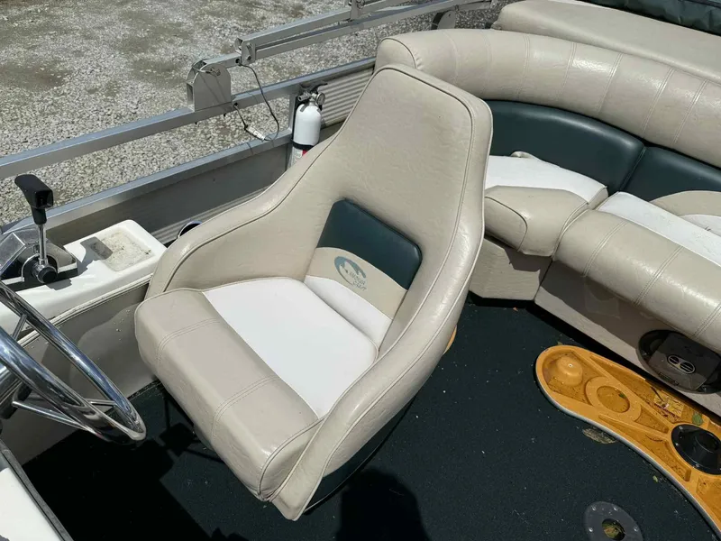 Slide: The Image of 1999 Smoker Craft 8526 Pleasure Isle I/O boat interior with beige seating and steering wheel. - 13