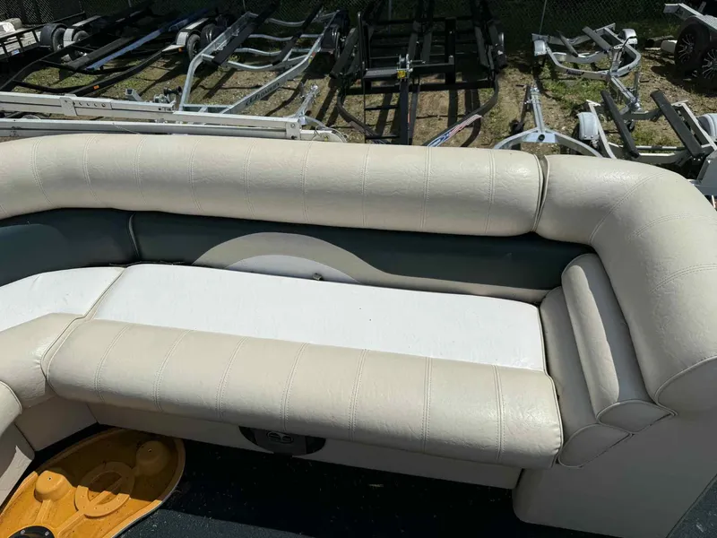 Slide: The Image of 1999 Smoker Craft 8526 Pleasure Isle I/O boat interior with beige seating and trailer background. - 14