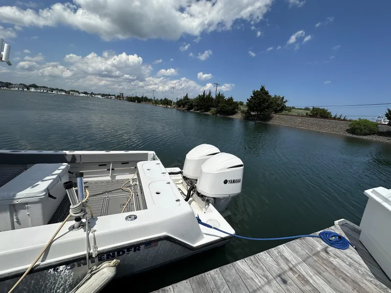 Slide: The Image of 2004 Contender 31 Fish Around boat docked, featuring Yamaha engines, under a partly cloudy sky. - 4