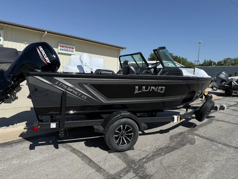 Slide: The Image of 2025 Lund 1775 Impact XS boat on trailer, displayed outdoors. - 2